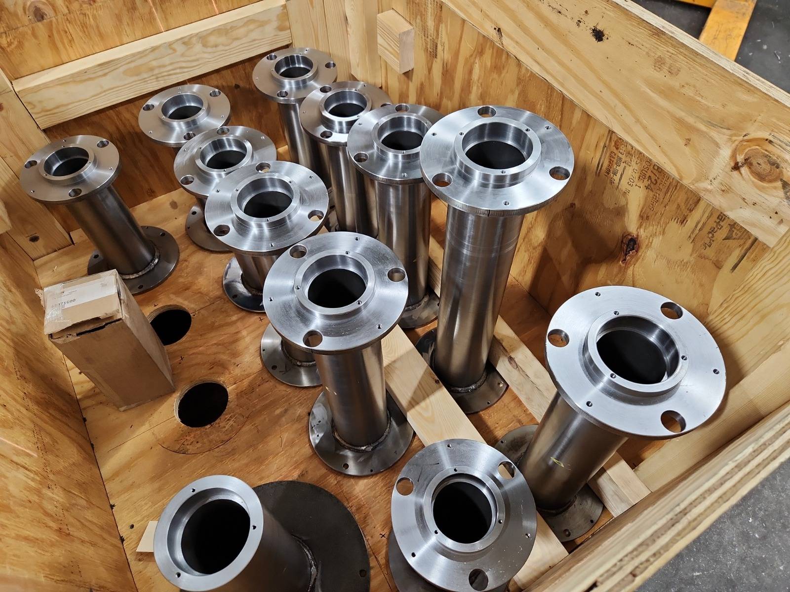 A crate of finished flanged shafts